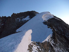 Arête neigeuse et sommet au fond.